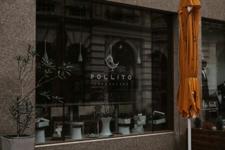 a store front with a yellow umbrella outside of it